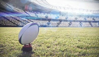3D render showing rugby ball sitting upright on kicking tee inside stadium with floodlights shining