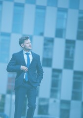 Businessman walking against building