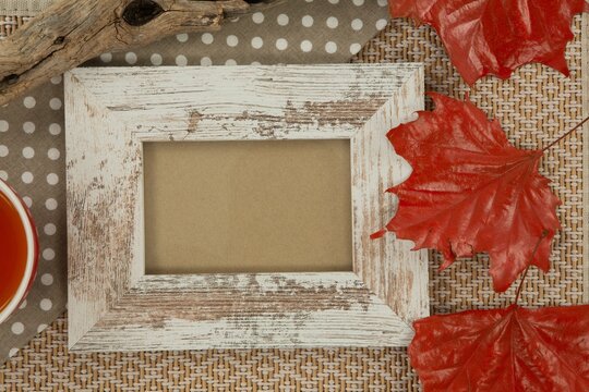 Photo frame and maple leaf on wooden table