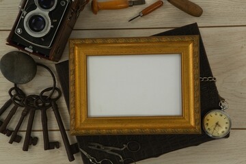 Photo frame, clock, keys, camera on wooden table
