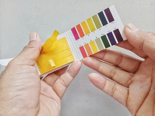 A man uses litmus paper to check the pH level. Laboratory work.