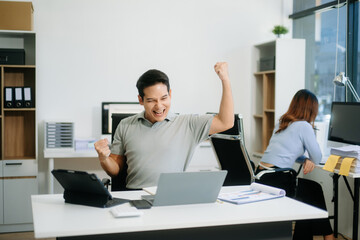 Asian businessman are delighted and happy with the work they do on their tablet, laptop and taking...