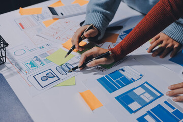 UX UI designer testing prototype on a phone, discussing and brainstorming on wireframes for a...