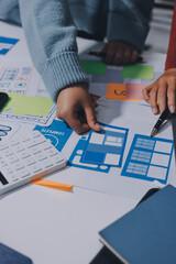 UX UI designer testing prototype on a phone, discussing and brainstorming on wireframes for a...