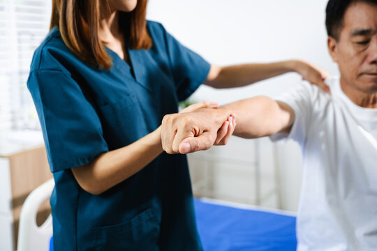 Female physiotherapist supports arm movement exercise for senior male patient during rehabilitation. Elderly care - Powered by Adobe