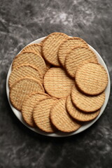 Crispy baked arrowroot biscuits served in white plate- top view.