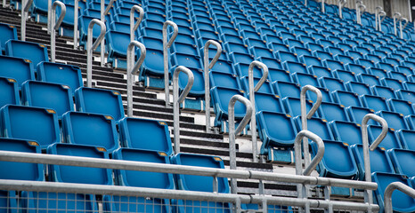 Naklejka premium multiple row of blue reserved empty chair, seat in stadium for soccer, football sport game and festival or concert in lined up in a row for audience