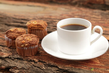 Delicious breakfast- freshly brewed coffee and chocolate muffins  served on a rustic wooden table.