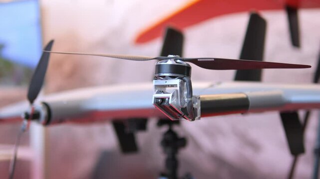 Drone with a black propeller is on display. The drone is on a stand and is surrounded by a wall