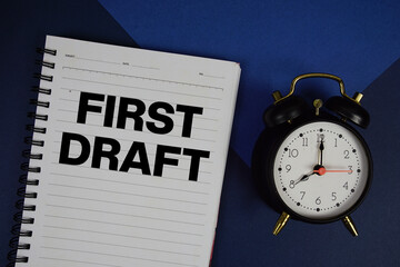 First Draft text written on notepad with alarm clock on navy blue background