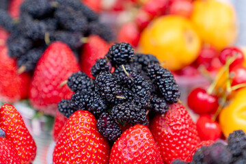 Assorted containers of berries for sale at a market. Fruits
