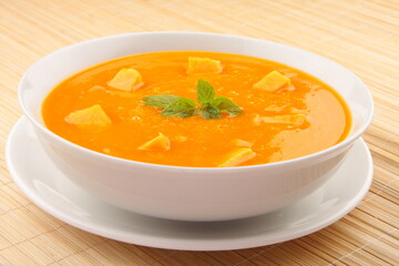 Fresh organic pumpkin cream soup, vegan diet foods background.