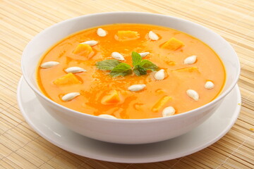 Bowl of delicious organic pumpkin soup, vegan diet meal  background.