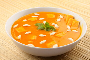 Homemade delicious and healthy fresh pumpkin soup  topped with pumpkin seeds.