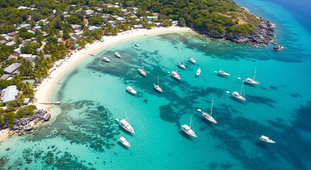 Scenic drone view of yachts and boats anchored in a shallow blue lagoon near a tropical island. Perfect for marine tourism, ocean leisure, and summer escape visuals.
