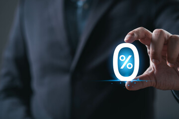 A businessman holds a glowing percentage symbol, symbolizing finance, metrics, or analytics in a...