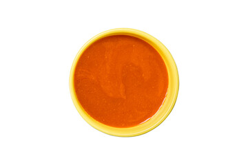 A bowl of vibrant orange tomato soup with a yellow rim isolated on transparent background