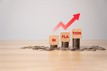 Inflation concept with rising red arrow and stacked coins under wooden blocks spelling INFLATION, symbolizing economic pressure, financial impact, cost increase, and monetary devaluation