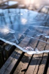 Translucent ice sheet on rustic wooden boards