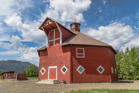 Iconic wooden red barn in Eastern Oregon with the Cascade Mountains in the background
