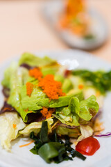 Fresh avocado salad is served in a plate, topped with egg shrimp. Healthy vegetable diet