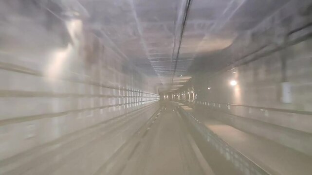 Point of view of train passing through underground tunnel in Malaysia. Front window view with rain droplets on it. 