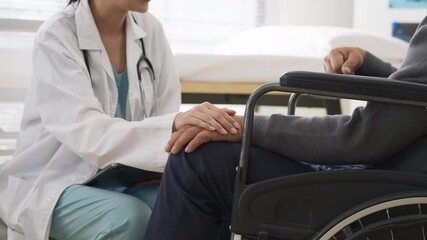 Close-up of a young Asian female doctor hold hand elderly patient in a wheelchair, focusing on mental health recovery and emotional support. The conversation takes place in a warm, trusted health - Powered by Adobe