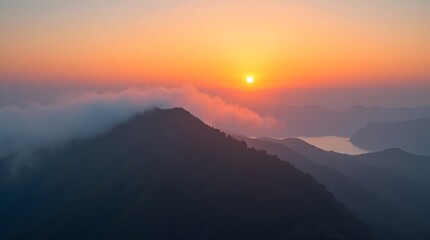 A breathtaking sunrise illuminates mountain peaks veiled in soft clouds, reflecting serenity and awe