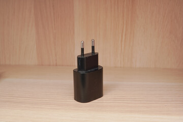 Black European two-pin power adapter photograph for tech product display or electronic accessory...