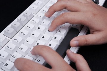 Detailed photographic capture of hands engaging white keyboard for technology articles digital...
