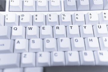 Close-up photograph of white QWERTY keyboard keys for technology blogs office or minimalist tech...