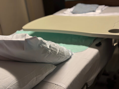 Clean Hospital Bed with Call Light and Overbed Table in Inpatient Room, Healthcare Facility Interior Showing Patient Care Environment, Clinical Recovery Setting, and Medical Room Setup