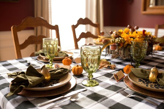 Thanksgiving table setting decorated with pumpkins, pears, and flowers