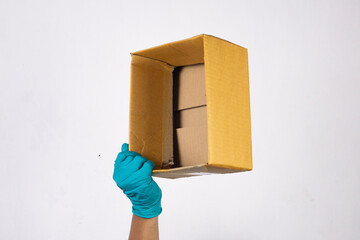 Man's hand wearing a glove holding a cardboard box. isolated on white background