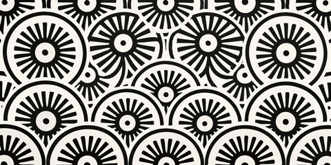 Black and white graphic pattern of repeating sunburst or wheel motifs