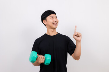 Positive asian man happy smile black shirt work out with dumbbell gesture point finger isolated