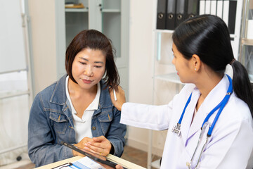 Female patient and doctor consultation in clinic, doctor comforting patient with empathy