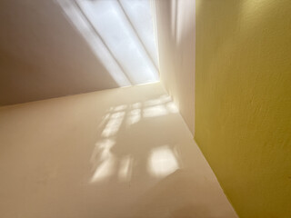 A corner of a room with a yellow wall and a white wall