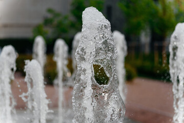 fountain of clean water in courtyard of residential complex, numerous jets of water, multi-storey...