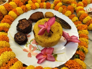 Hindu blessed food for God and rituals as per culture, offerings to the deity, or sacred food for grace or blessing in religious offering in Hinduism. Decorated with marigold flowers and garlands.