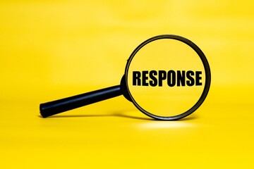 RESPONSE concept zoomed through a magnifying glass isolated on a yellow background.