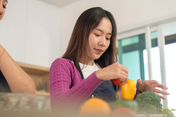Healthy Cooking Together. Two women preparing fresh vegetables in a bright kitchen.