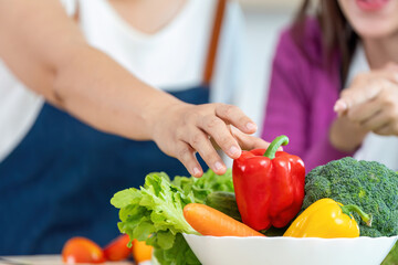 Healthy Cooking Together. Close-up of hands reaching for fresh vegetables in a kitchen.