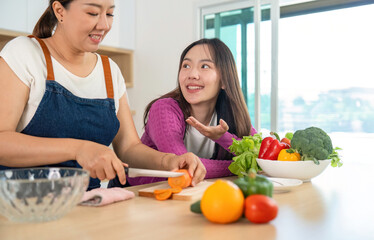 Healthy Cooking Together. Two women preparing fresh vegetables in a modern kitchen.