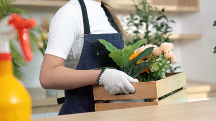 Floral Arrangement and Delivery. Young woman carrying a wooden crate of flowers.