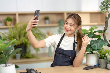 Selfie Moment in Nature. Young woman taking a selfie in a lush indoor garden with plants.