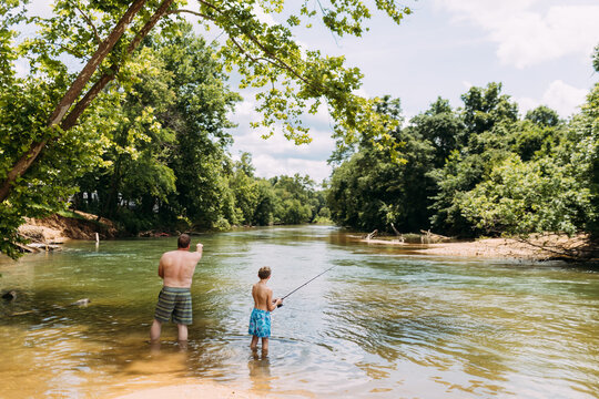 Dad and son on Father's Day fishing together in shallow river