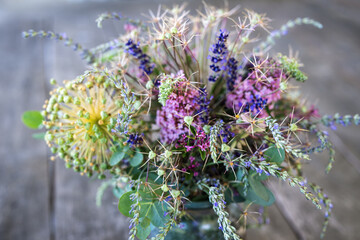 Bouquet of dried and some fresh garden flowers on a garden table outside