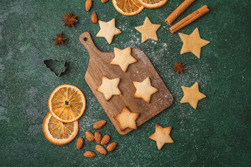 Christmas star cookie dough and oranges on green background for festive baking and seasonal concept
