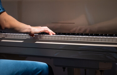 Female hands and white pianoforte keys